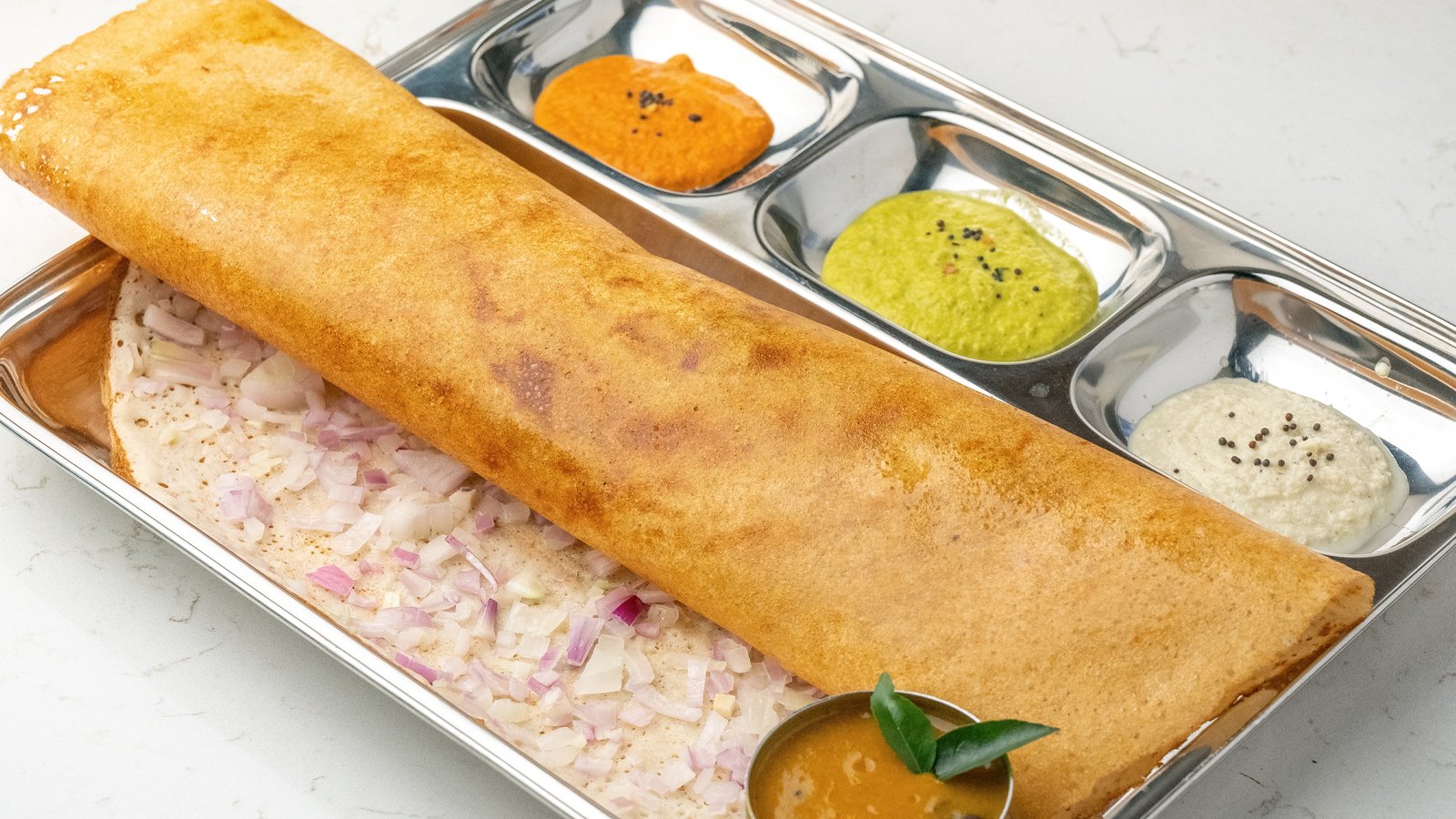 Crispy Onion Dosa topped with fresh onions served at Sangam Vegetarian Restaurant